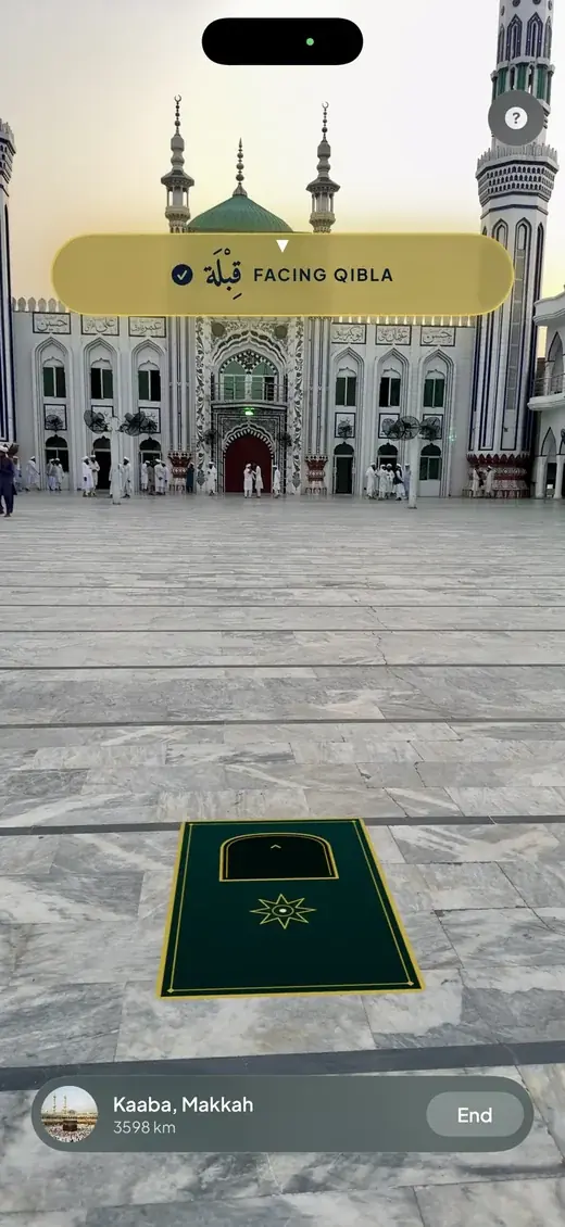 The Athanify AR Qibla finder showing a prayer mat placed on the floor through the camera, with a banner reading Facing Qibla