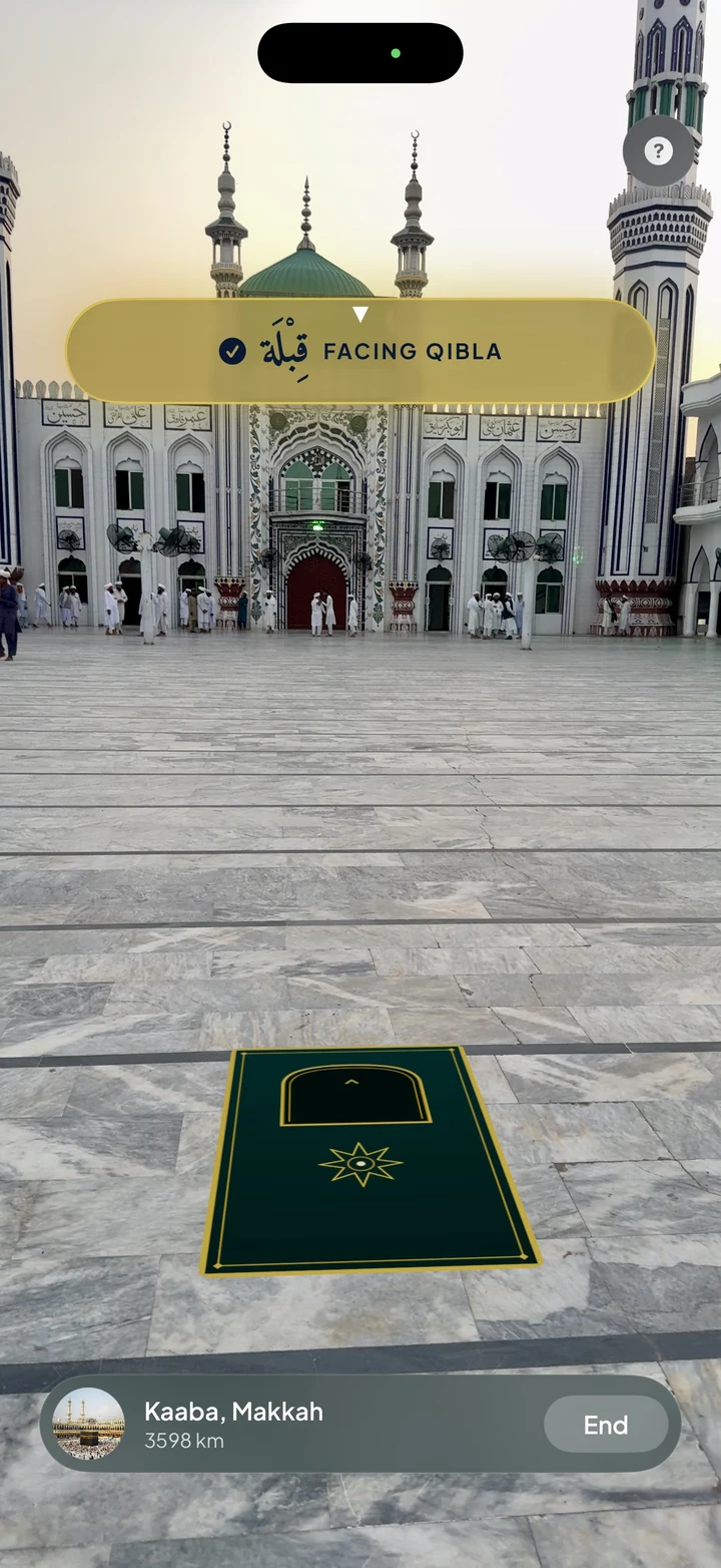 The Athanify AR Qibla finder showing a prayer mat placed on the floor through the camera, with a banner reading Facing Qibla